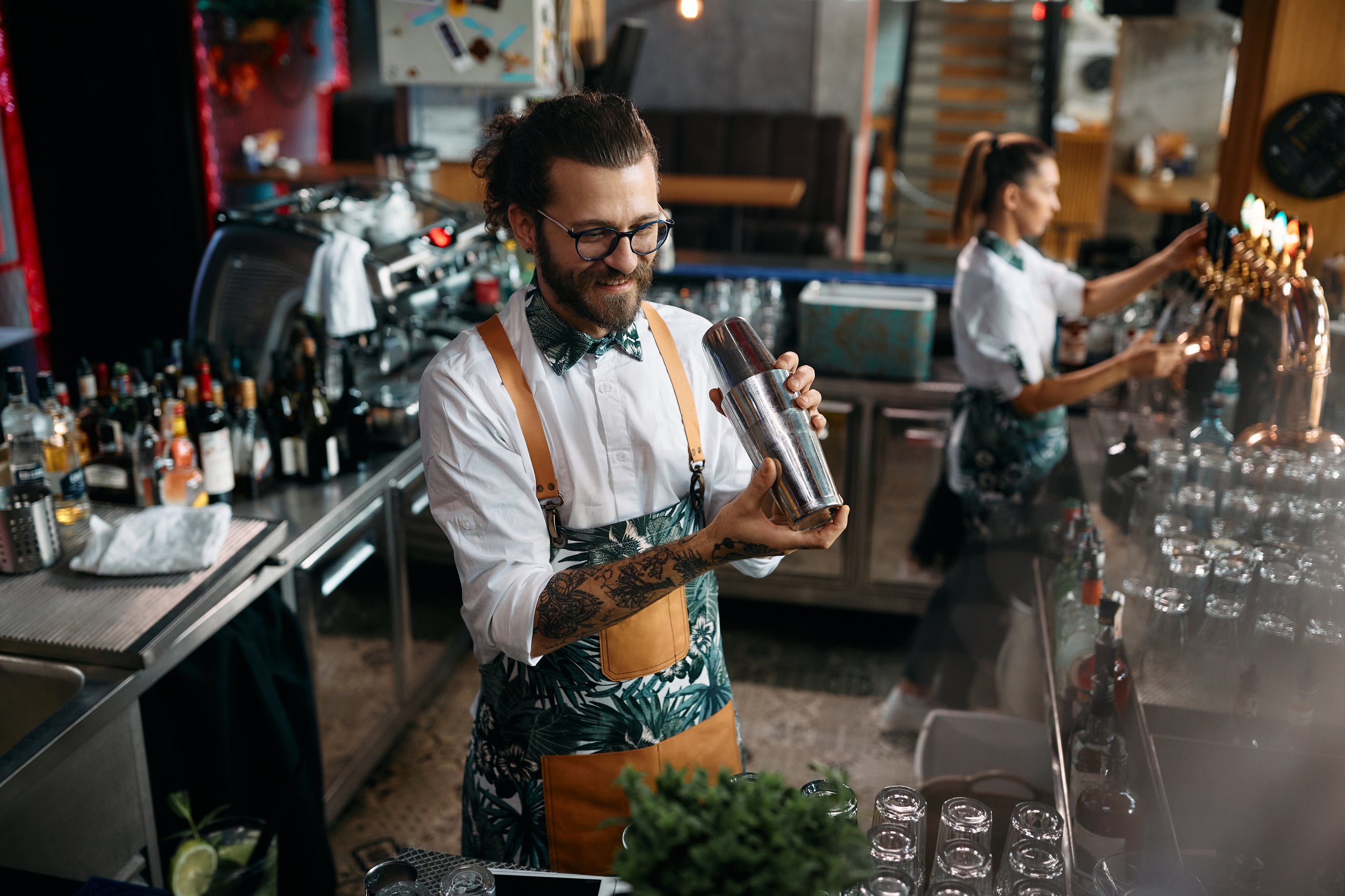 Bartender shaking cocktail, working in a bar.