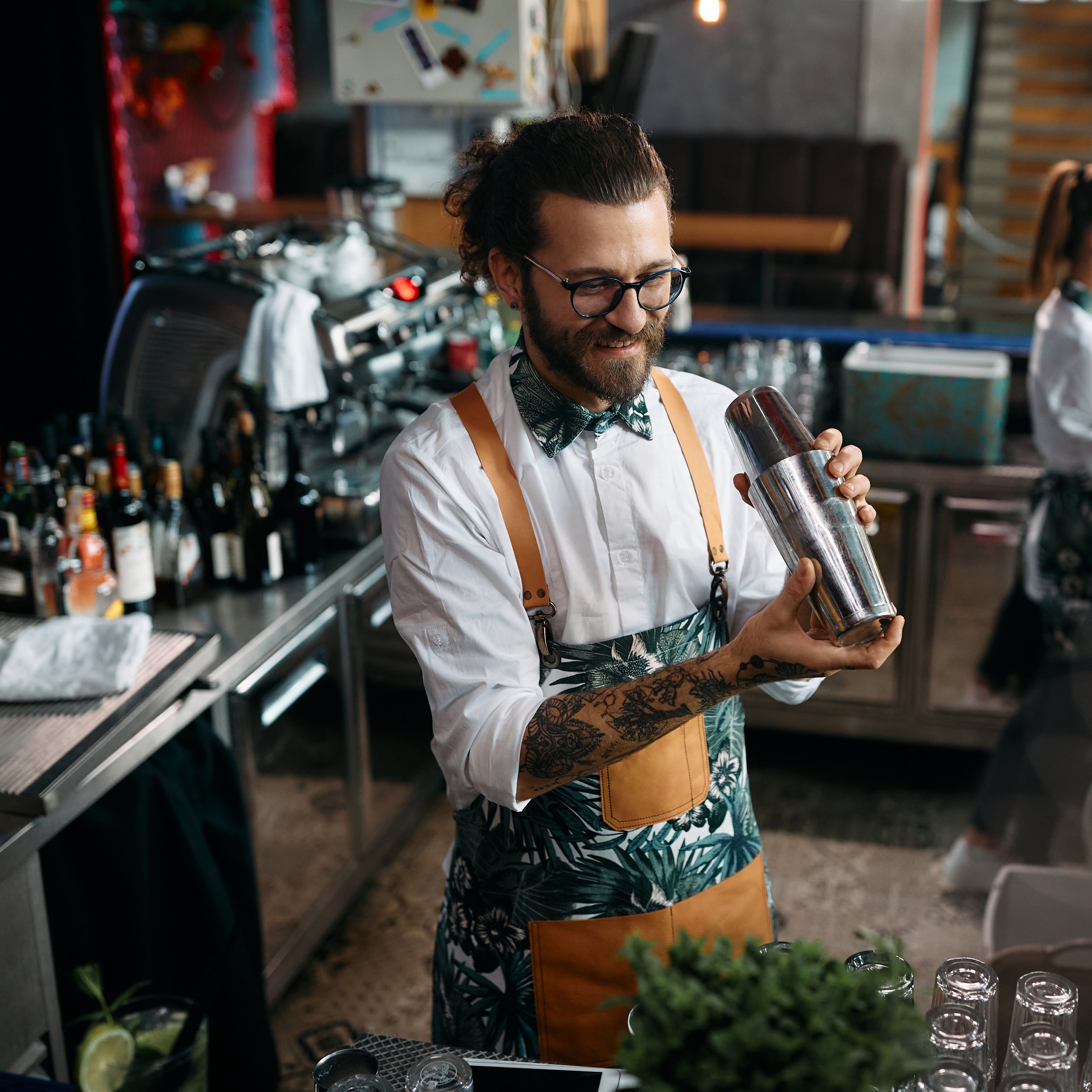 Bartender shaking cocktail, working in a bar.