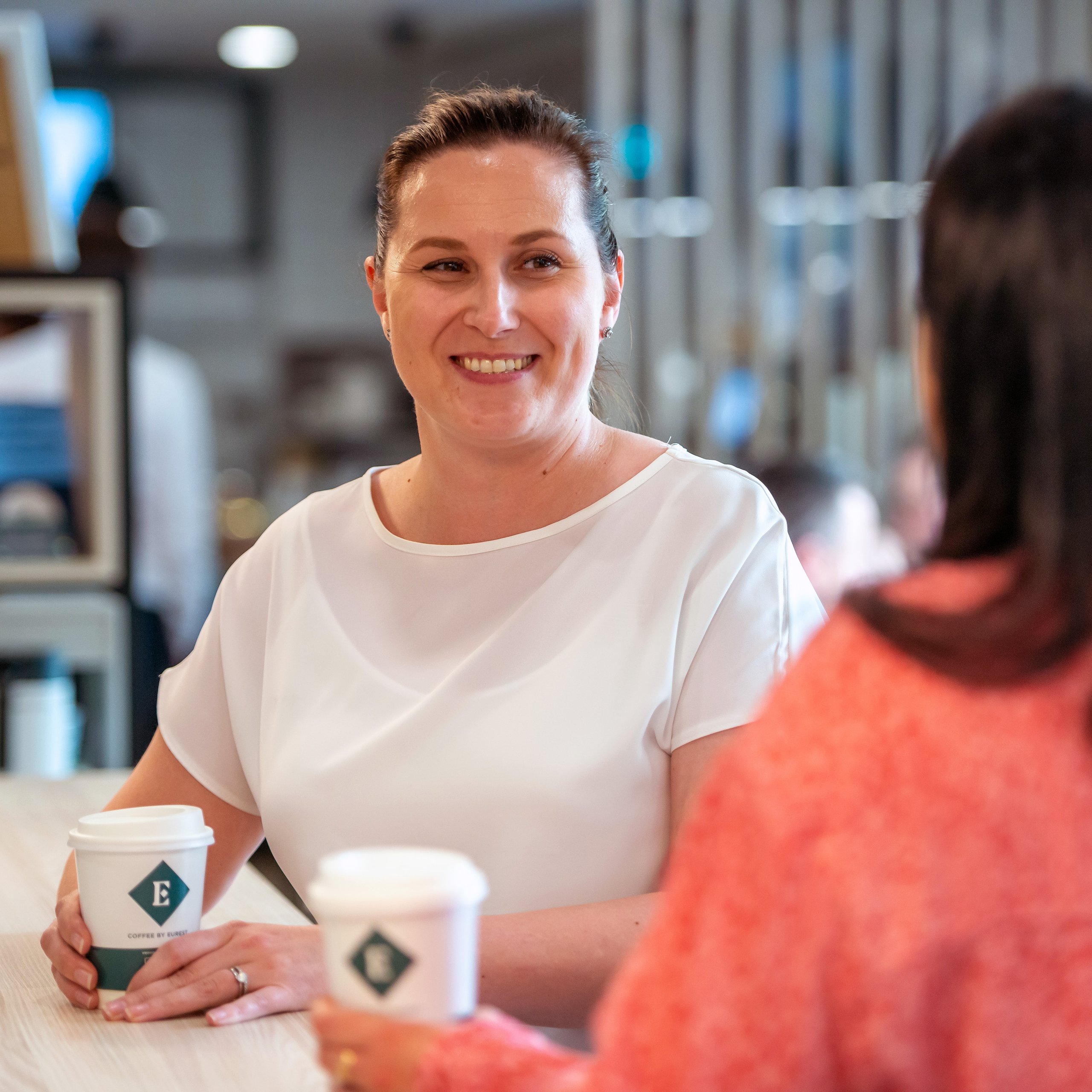 Two women talking over coffee in a coffee shop.