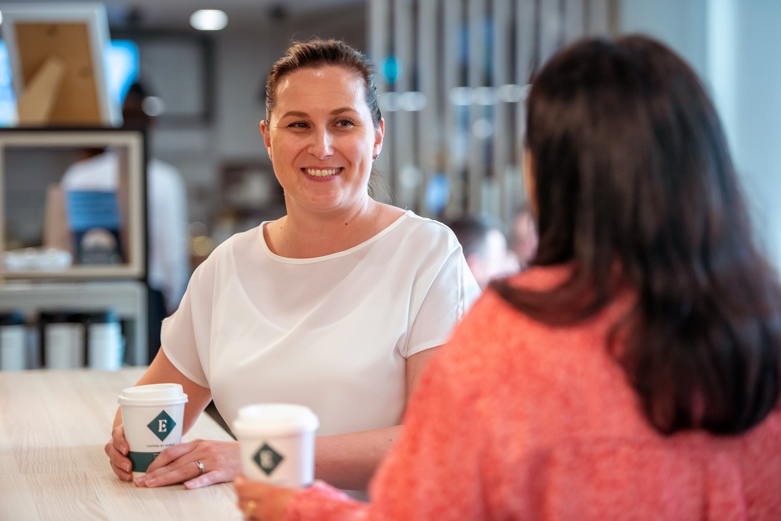 Two women talking over coffee in a coffee shop.