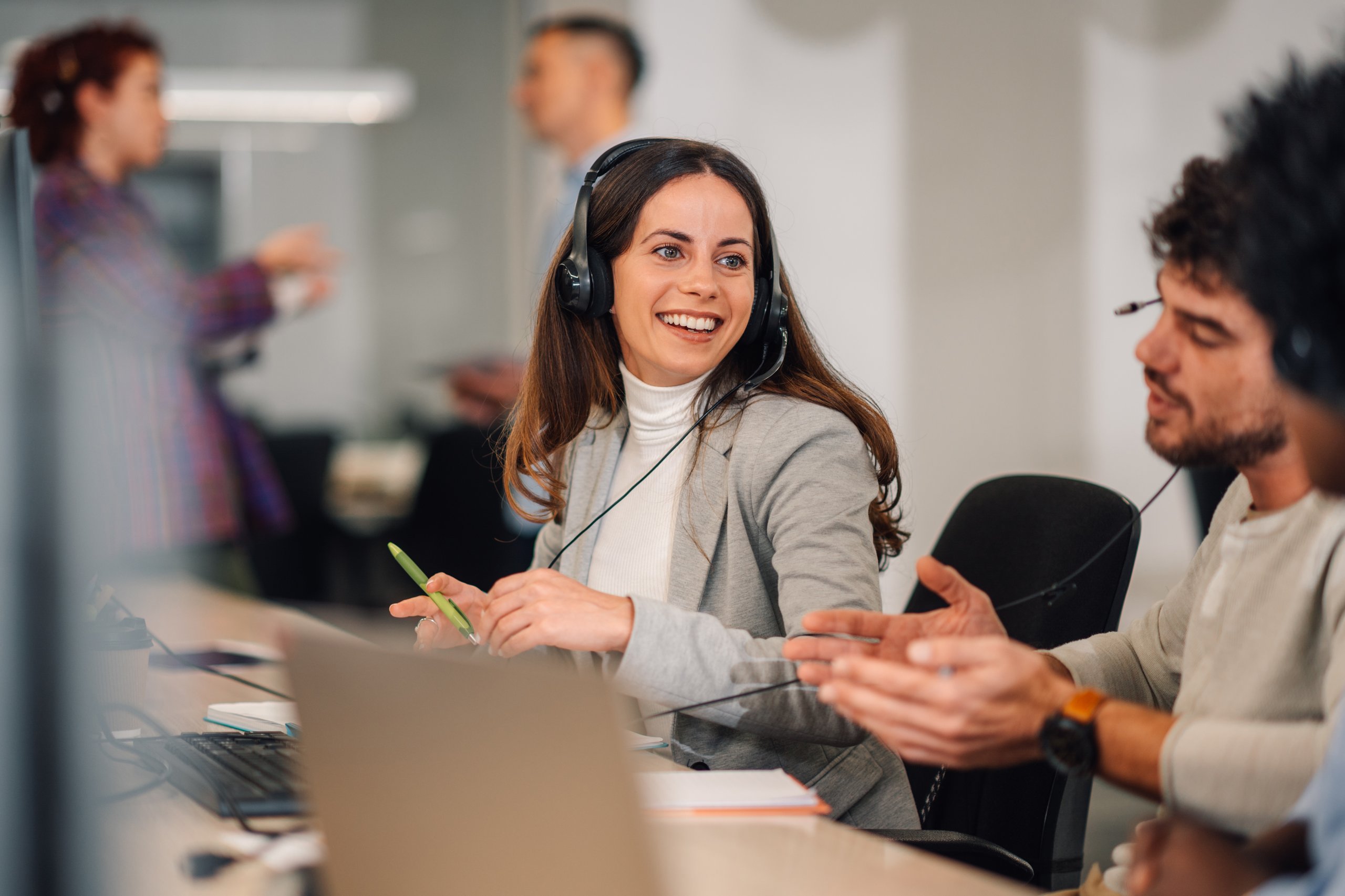 People wearing headsets, smiling while talking.