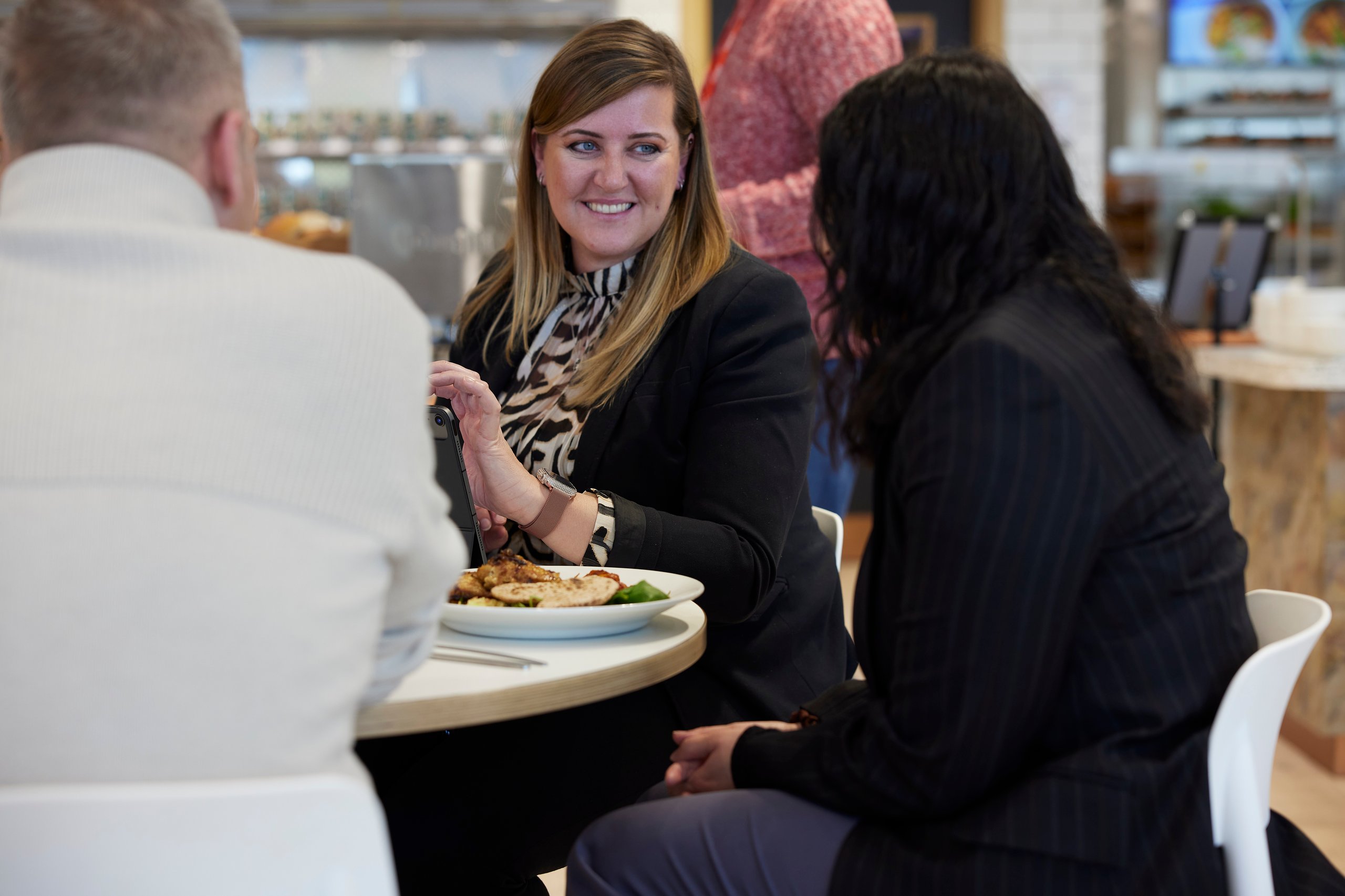 People at a table with food, discussing.