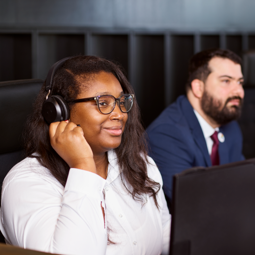 People wearing headsets working at desks.